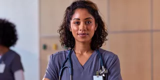 Smiling healthcare professional stands with her arms crossed
