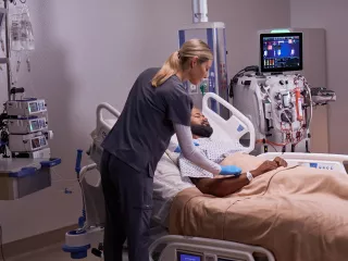 nurse at bedside providing multi-organ support for critically ill patient